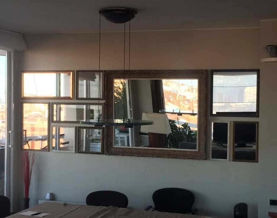 Composición decorativa de siete espejos a medida con marcos dorados de distintos tamaños y estilos clásicos instalados en galería sobre pared de comedor, con espejo central de gran formato y espejos pequeños alrededor, trabajo realizado por Contell Marcs.