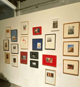 Sala de exposición de arte contemporáneo con composición mural de obras enmarcadas por Contell Marcs en marcos negros de perfil fino y un marco dorado clásico en pared lateral,Barcelona.