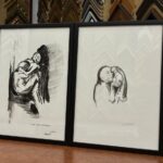 Díptico de dos grabados en tinta negra sobre papel blanco con figuras humanas expresionistas, enmarcados con marcos negros finos y paspartú blanco, apoyados en el mostrador del taller Contell Marcs de Barcelona con molduras al fondo.